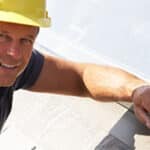 Roofer Working On Exterior Of New Home