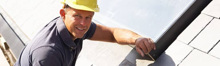 Roofer Working On Exterior Of New Home